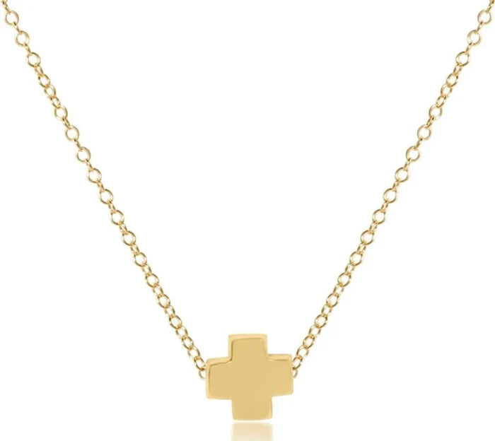 Gold cross necklace on a white background