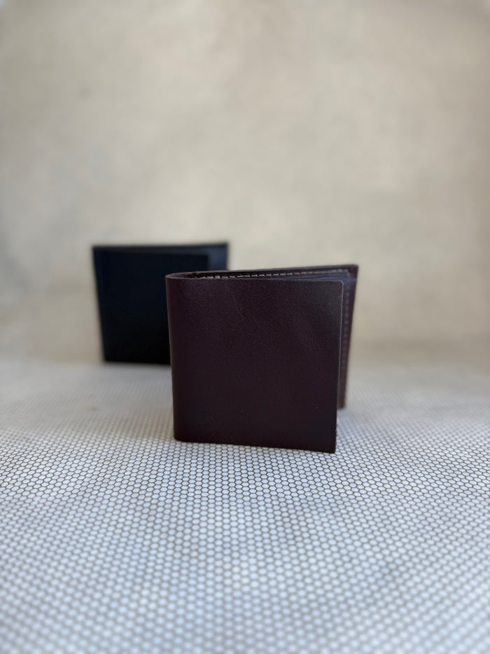 Dean bifold leather wallet made in LA in brown and black on neutral background.