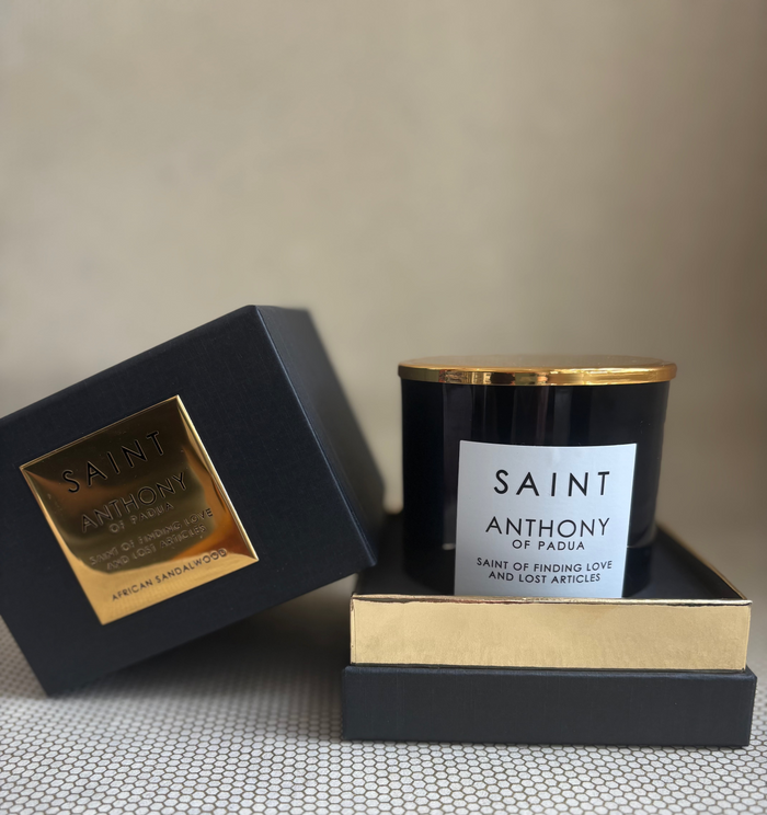 SAINT black glass candle with gold lid. black and gold box for candle. 11 oz. (8 oz. pour), Measures 3.5" H x 3" D.