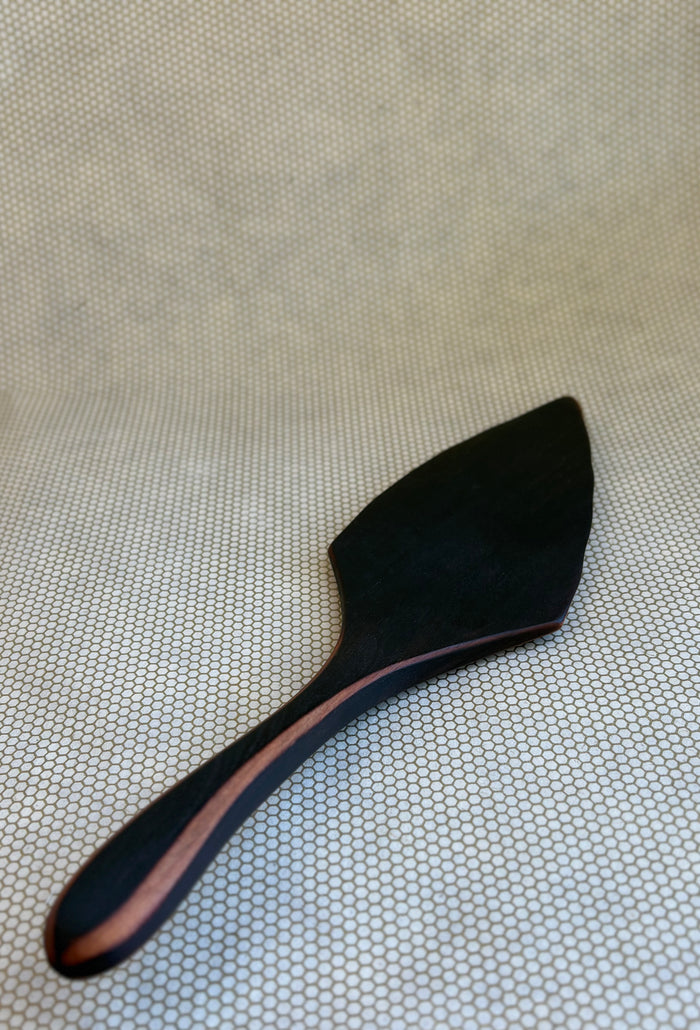 Jonathan's Spoons blackened natural wooden pie server on light natural background.