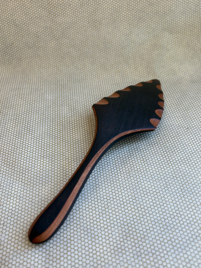 Jonathan's Spoons blackened natural wooden pie server on light natural background.