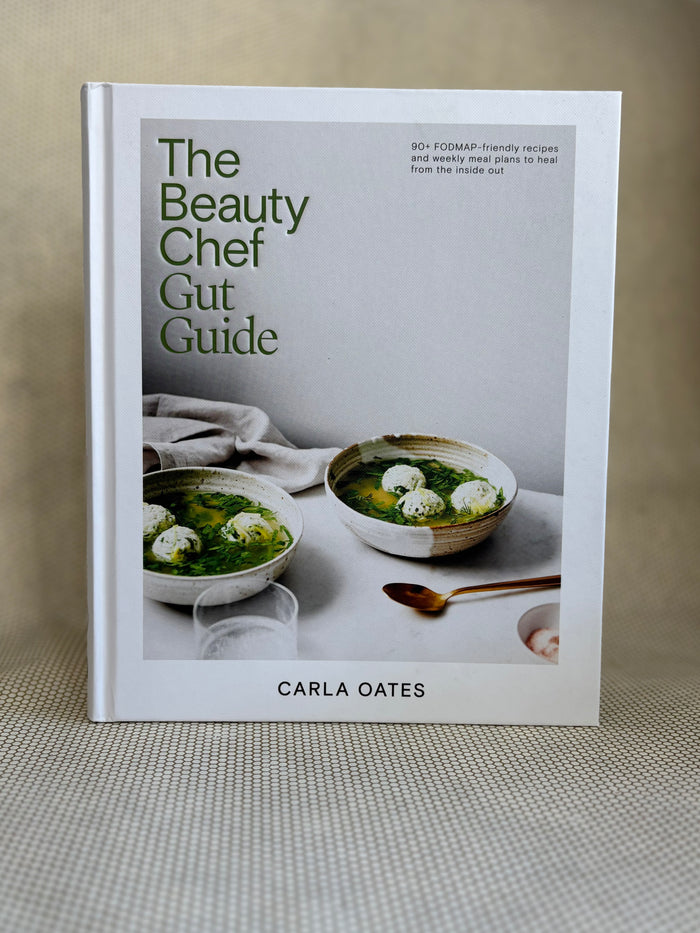 book titled "the beauty chef gut guide" by Carla Oates on neutral background.