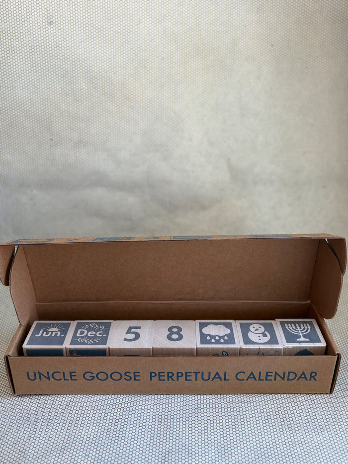 Uncle Goose Perpetual Calendar blocks in packaging on a textured surface