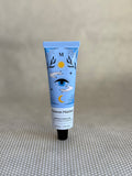 blue tube with artistic design of Maison Matine Minus Cumulus hand cream on neutral background.