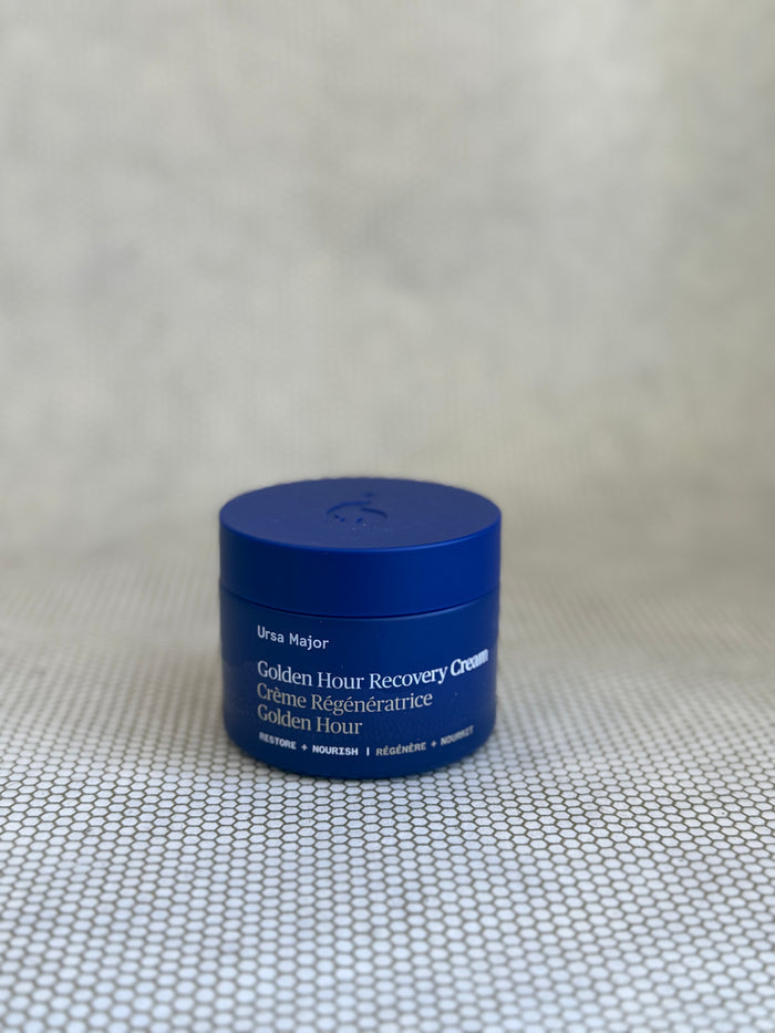 Blue traveler jar of Ursula Major Golden Hour Recovery Cream on a textured beige background
