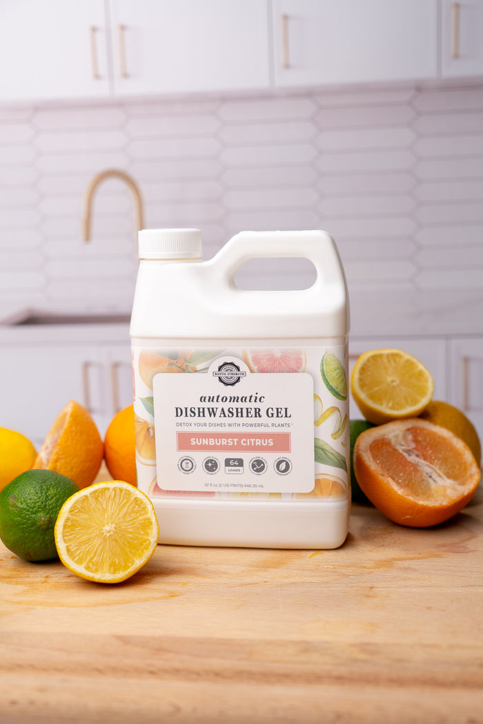 Rustic Strength, Image of 32 oz  Automatic Dishwasher Gel and sliced limes, lemons, and oranges on a kitchen counter.