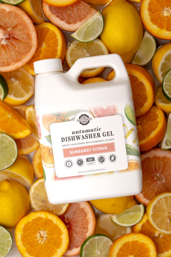 Rustic Strength, Automatic Dishwasher Gel, 32 oz Plastic, Sunburst Citrus , Laying on a bed of sliced citrus fruit