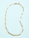 Gold necklace on a light blue background