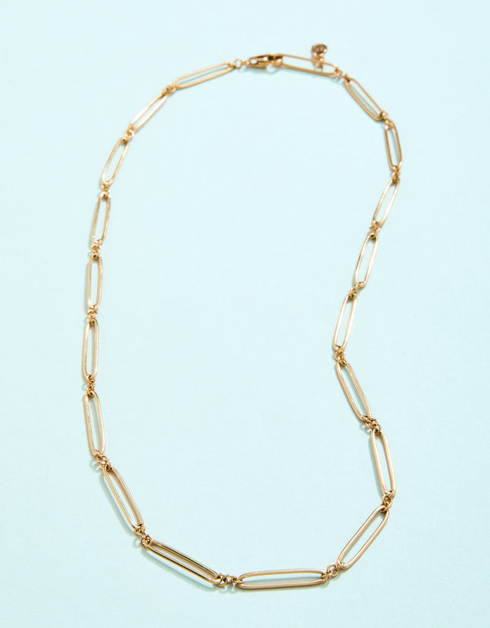 Gold necklace on a light blue background