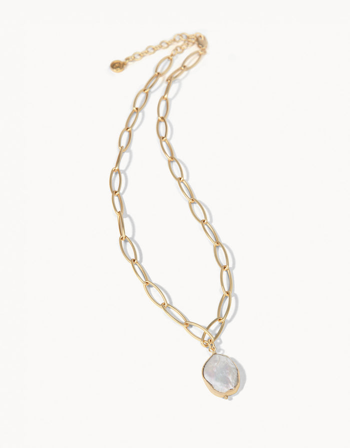 Gold chain necklace with a moonstone pendant on a white background