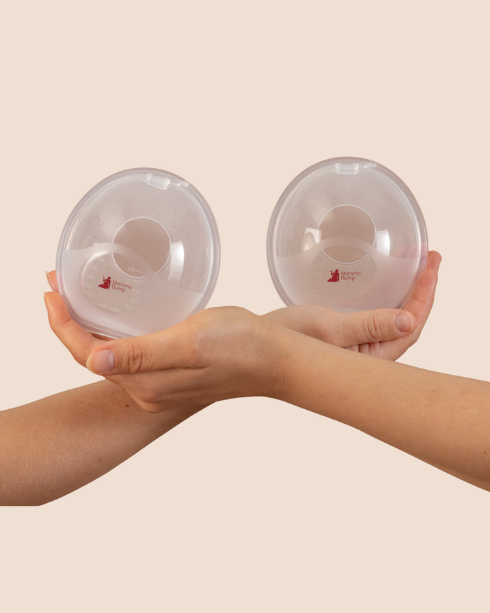 MammaBump breast milk collectors held in hands, designed to catch natural letdown while you nurse on the other side