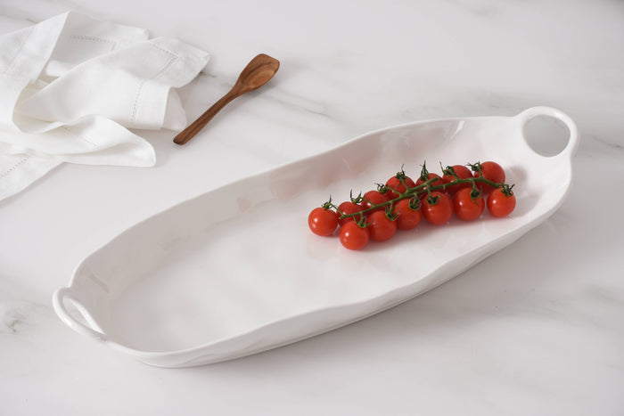 White ceramic platter with cherry tomatoes on a light gray background