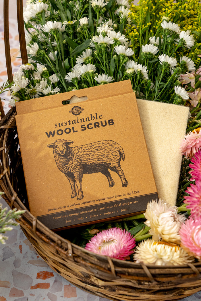 Rustic Strength, wool scrub in cardboard box sitting in a basket of flowers