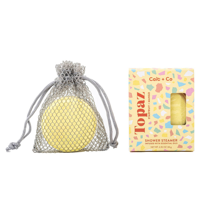 yellow shower steamer in and out of packaging displayed against a white background