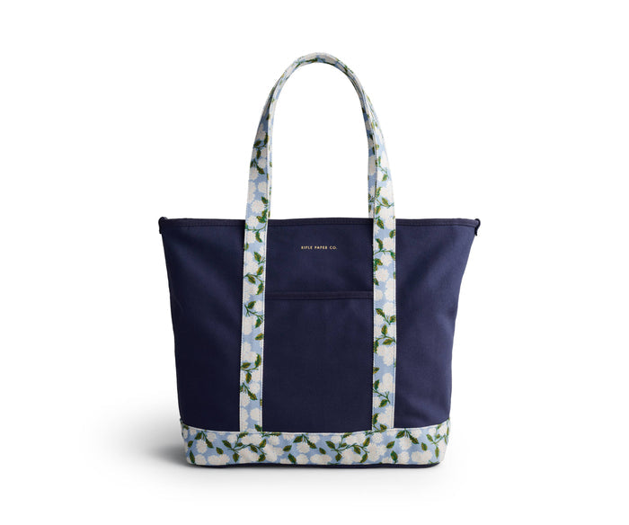 Navy tote bag with floral patterned handle and base on a white background