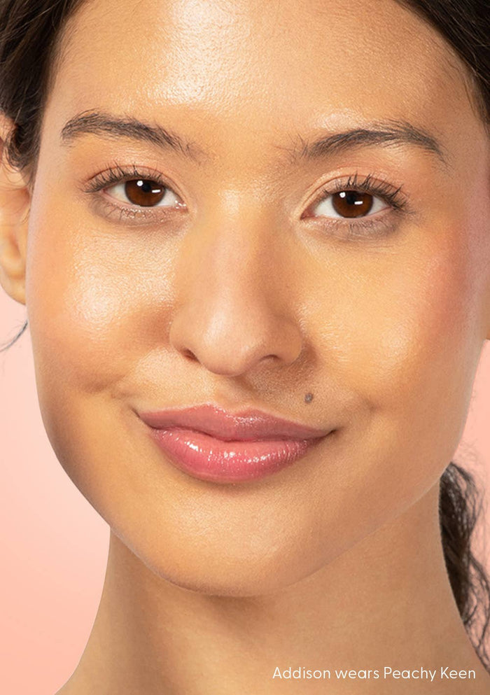 Close-up of a woman wearing pink lipstick on a pink background