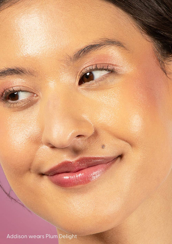 Close-up of a woman's face with makeup, wearing 'Plum Delight' by Addison.