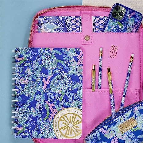 Pink pouch with blue and white patterned items including a notebook, phone case, and pouches.