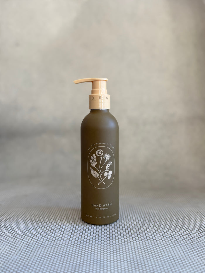 brown pump bottle of My Neighbor's wild bergamot hand wash with floral design.
