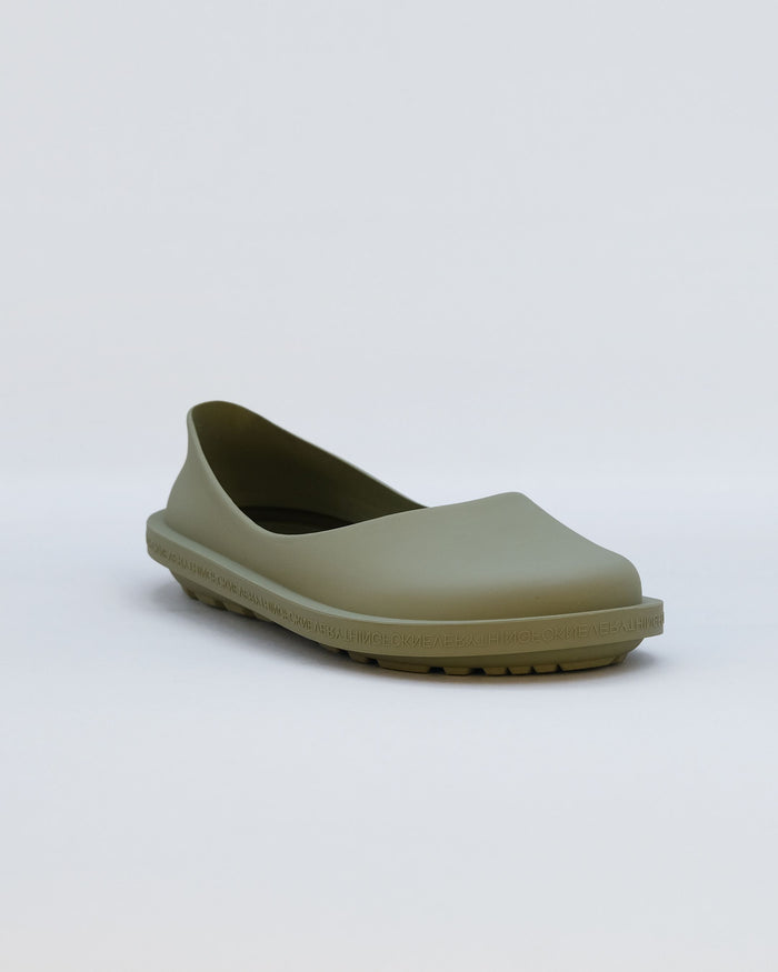 Moss-colored rubber clog with curved upper and textured sole against white background.