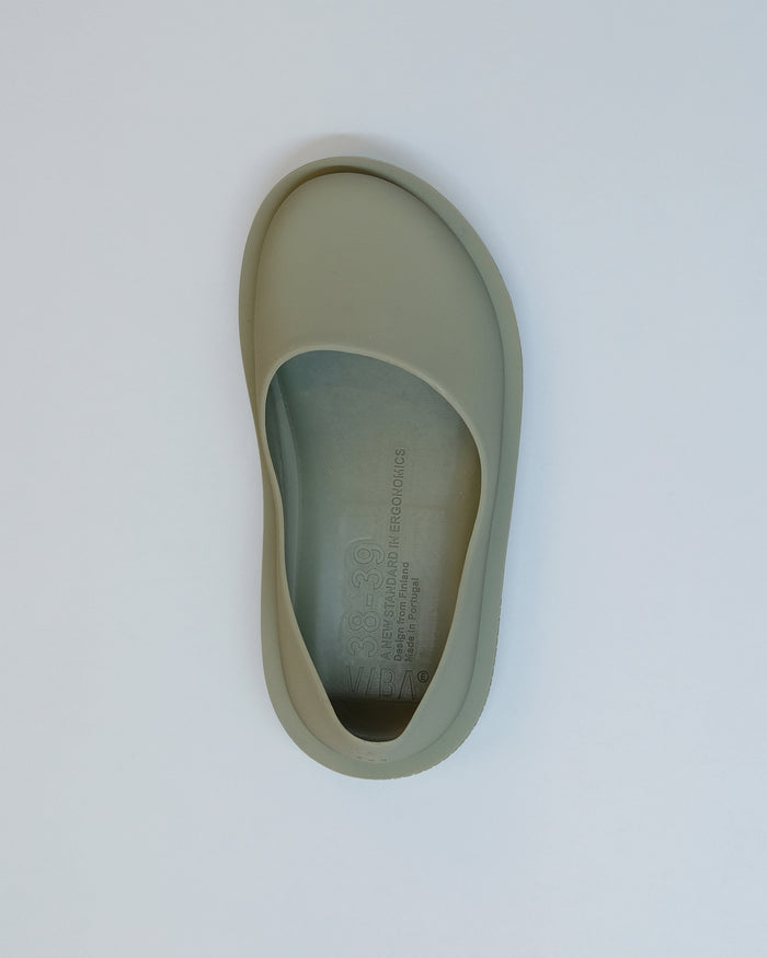 Overhead view of a sage green slip-on shoe with natural rubber sole and molded footbed.