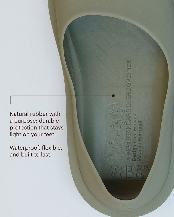 Moss-green natural rubber sole with embossed branding and product details visible on the surface.