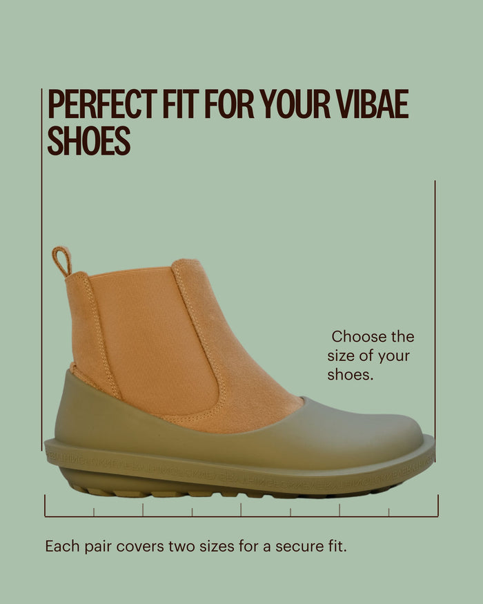 Tan and olive natural rubber slip-on boot with pull tab, shown against mint green background.