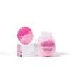 A pink bath bomb with a clear packaging that reads 'CAIT + CO. BATH BOMB' and a decorative bow, placed on a white stand against a white background.