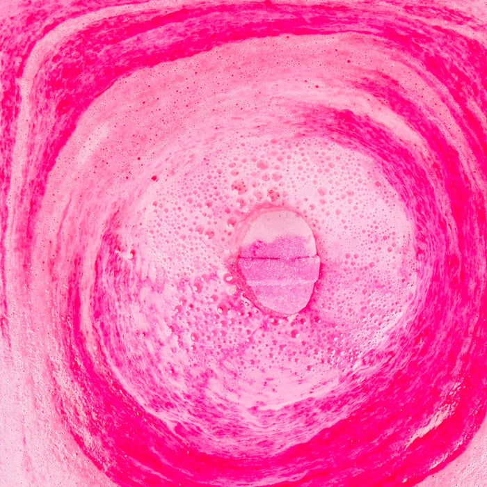 a pink bath bomb dissolving in water
