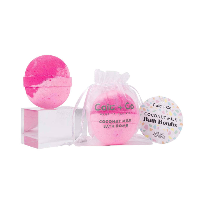 a pink Cait + Co bath bomb and its packaging displayed against a white background