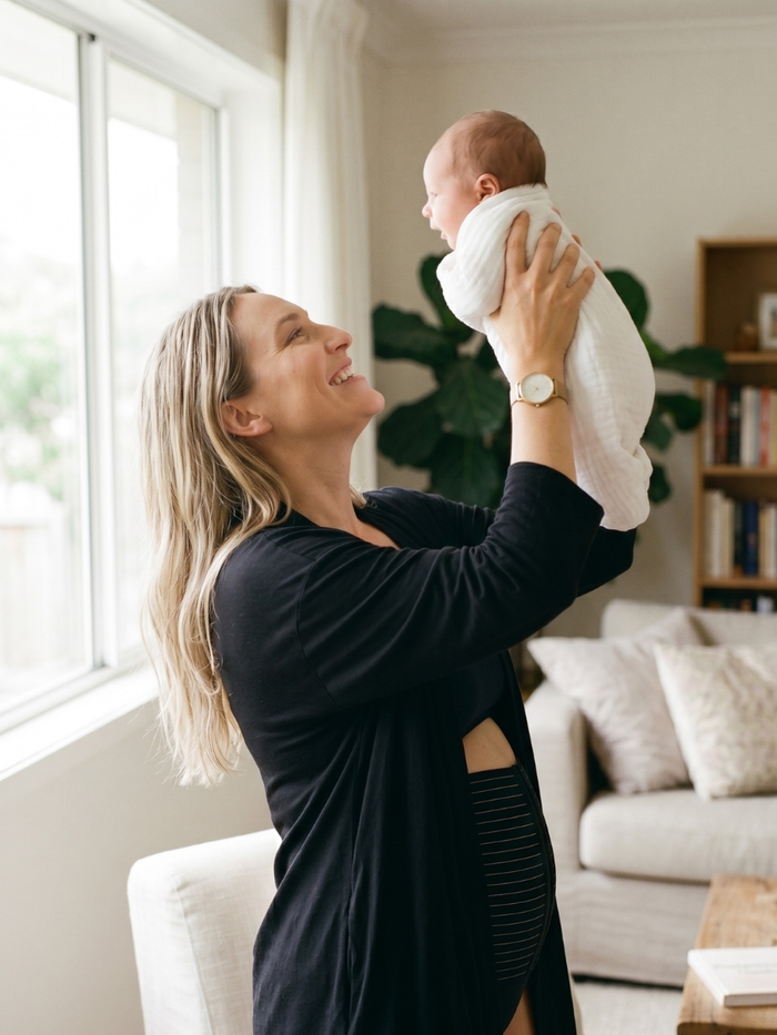 postpartum-mom-wearing-belly-band-lifting-her-baby