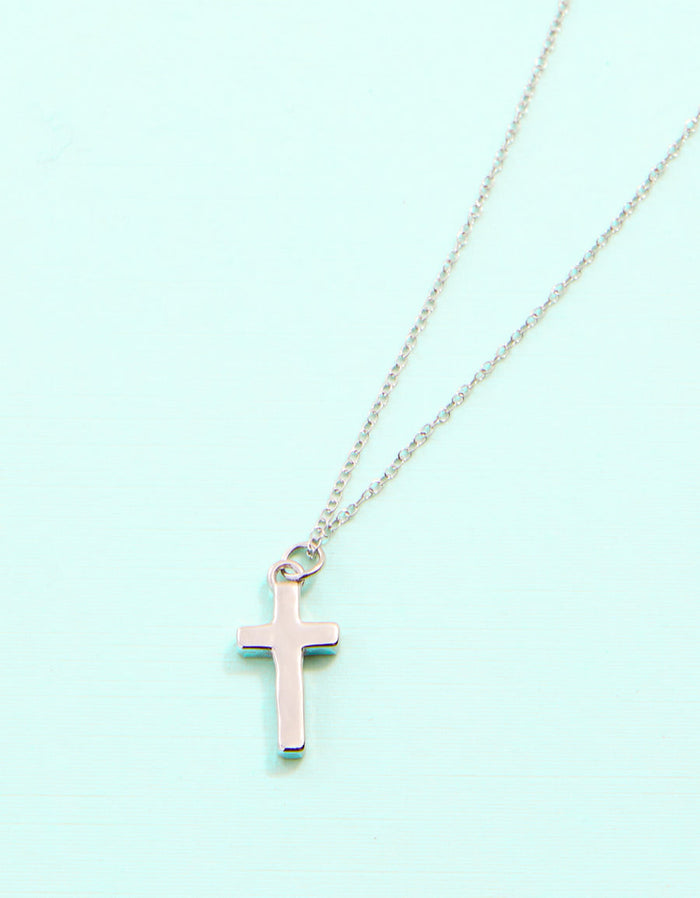 Necklace with a pink cross pendant on a light blue background