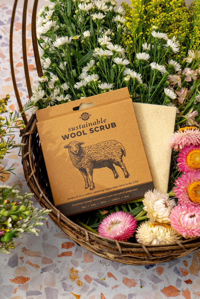 Rustic Strength, wool scrub in cardboard box sitting in a basket of flowers