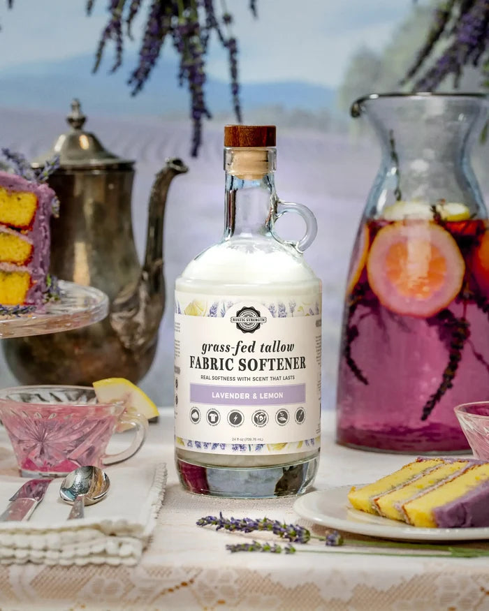 Rustic Strength -Tallow Fabric Softener | 24oz Glass | Lavender & Lemon  beside a pitcher of lavender lemonade and a slice of cake