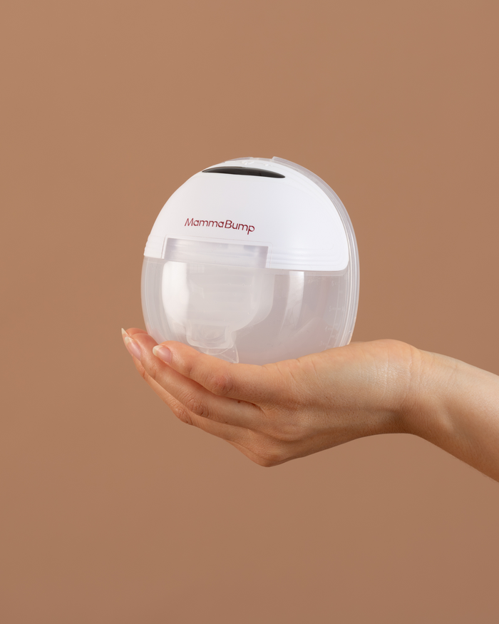 A hand is holding the luna wearable breast pump.
