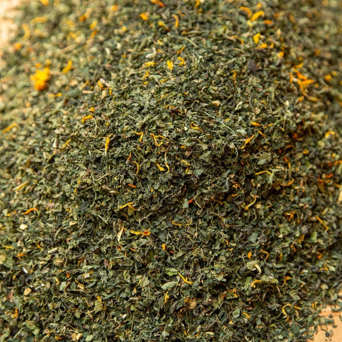 Dry green tea leaves on a wooden surface
