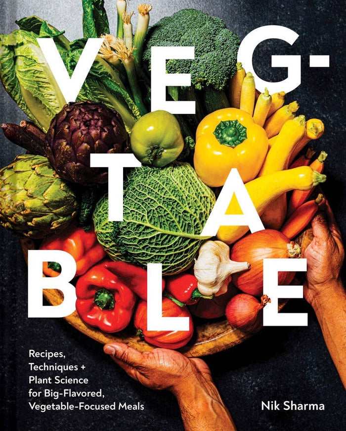 A book cover of 'Veg-table' featuring a bunch of various vegetables arranged in a wheelbarrow, with the title prominently displayed.