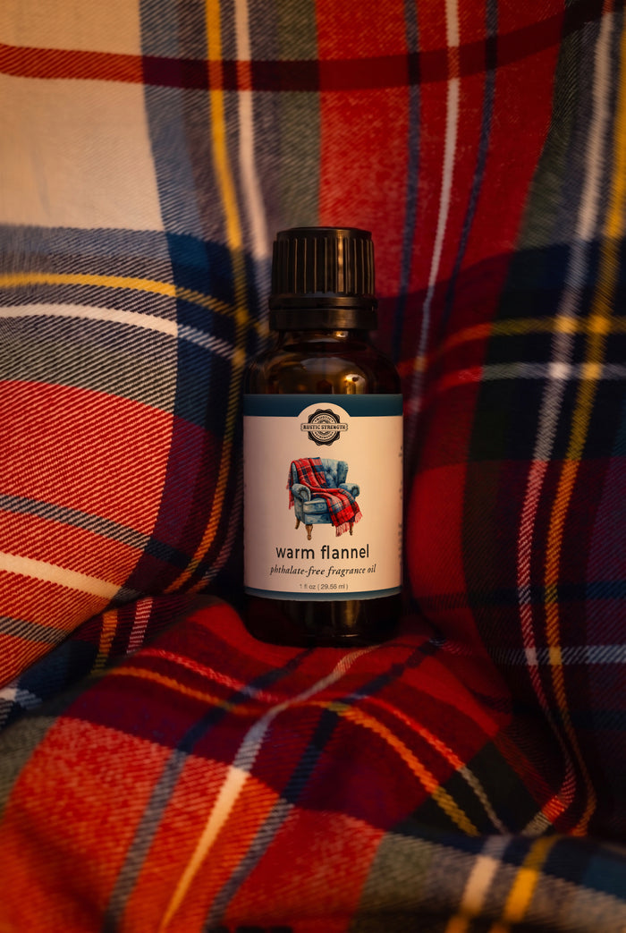 Rustic Strength - Phthalate-Free Fragrance Oil | 1oz Amber Glass Vial | Warm Flannel, set on a red-dominant flannel fabric background