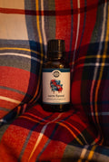 Rustic Strength - Phthalate-Free Fragrance Oil | 1oz Amber Glass Vial | Warm Flannel, set on a red-dominant flannel fabric background