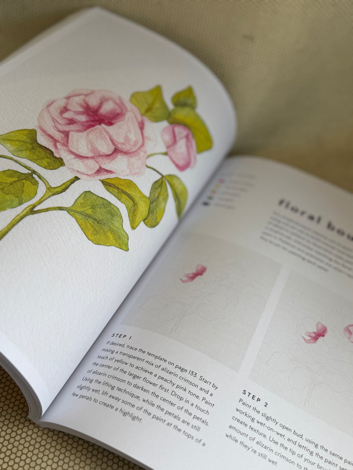 Open book with floral illustrations and text on a textured surface